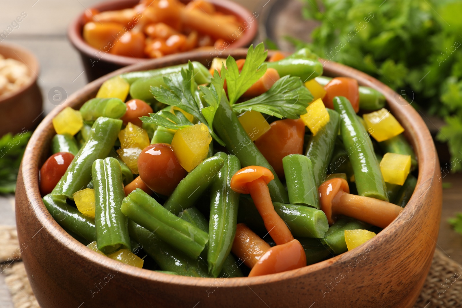 Photo of Bowl of tasty salad with green beans on table, closeup view