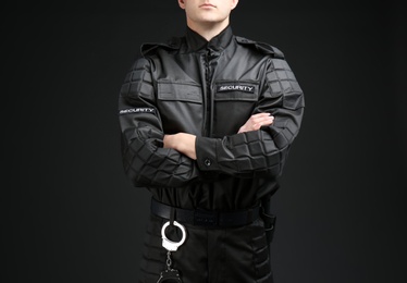 Male security guard in uniform on dark background