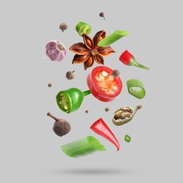 Image of Different spices falling on light grey background