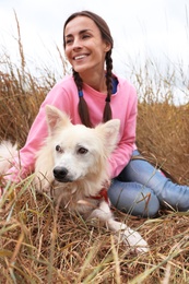 Female volunteer with homeless dog at animal shelter outdoors