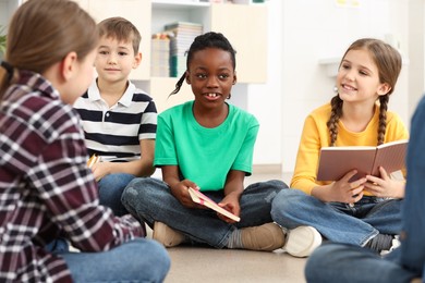 Cute children discussing homework in classroom at school
