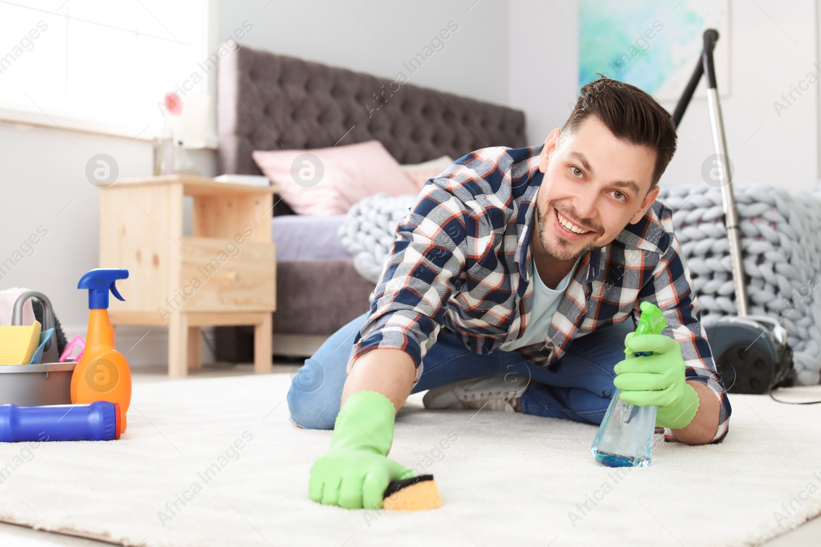 Photo of Mature man cleaning carpet at home