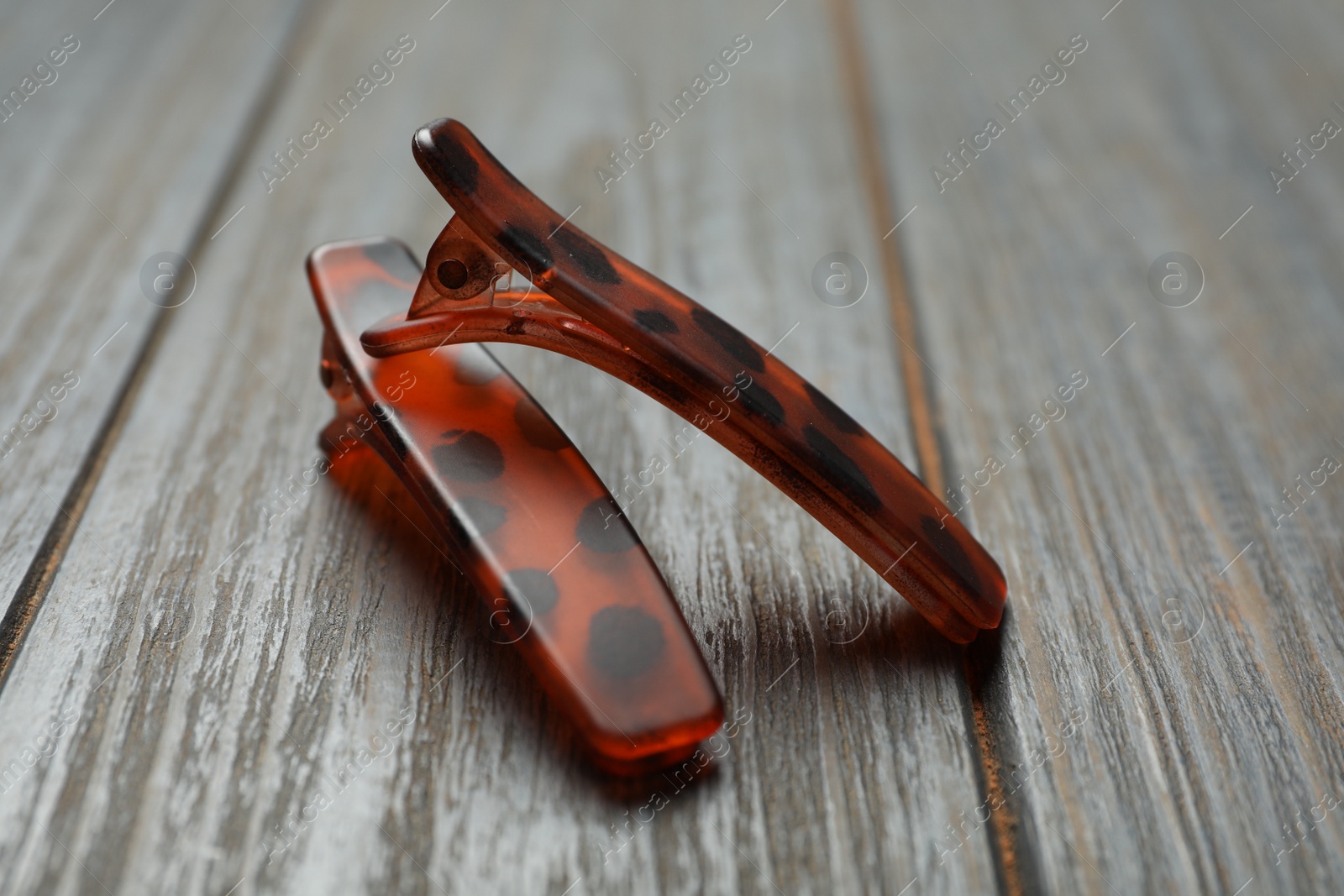 Photo of Stylish hair clips on grey wooden table