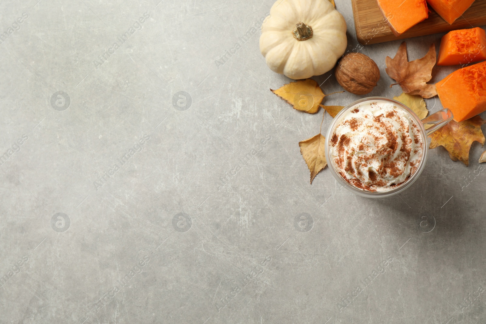 Photo of Delicious pumpkin latte on light grey table, flat lay. Space for text