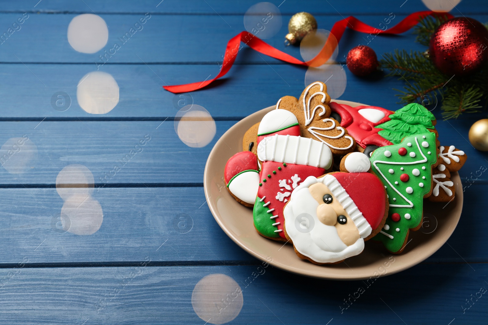 Photo of Different tasty Christmas cookies and decor on blue wooden table, space for text