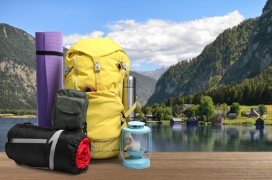 Image of Camping equipment for tourist on wooden surface and beautiful view of mountain landscape