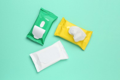 Photo of Wet wipes flow packs on turquoise background, flat lay