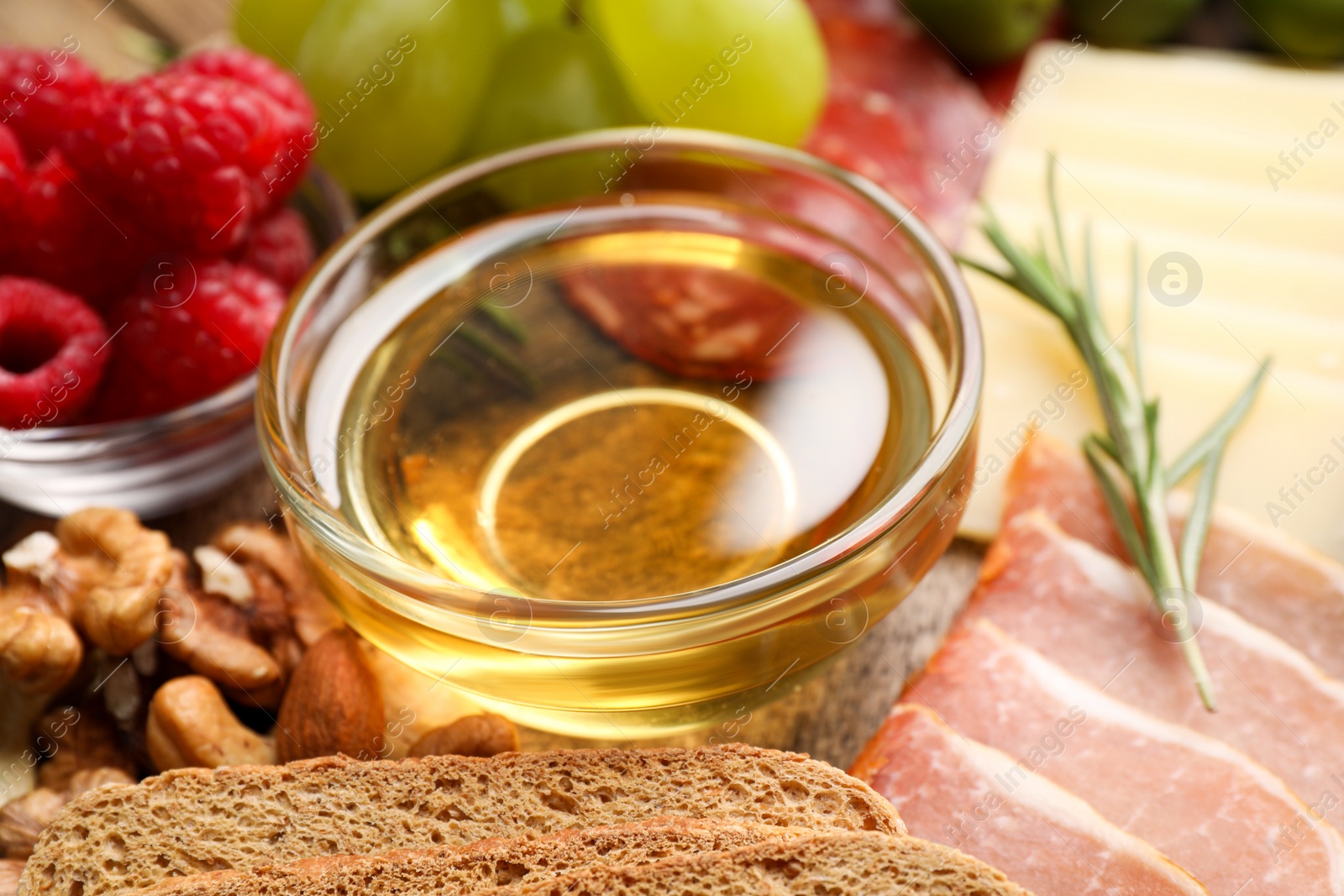 Photo of Snack set with delicious Parmesan cheese and honey on plate, closeup