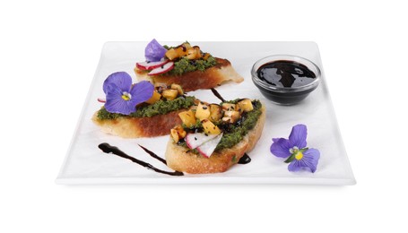 Photo of Delicious bruschettas with pesto sauce, tomatoes, balsamic vinegar and violet flowers isolated on white