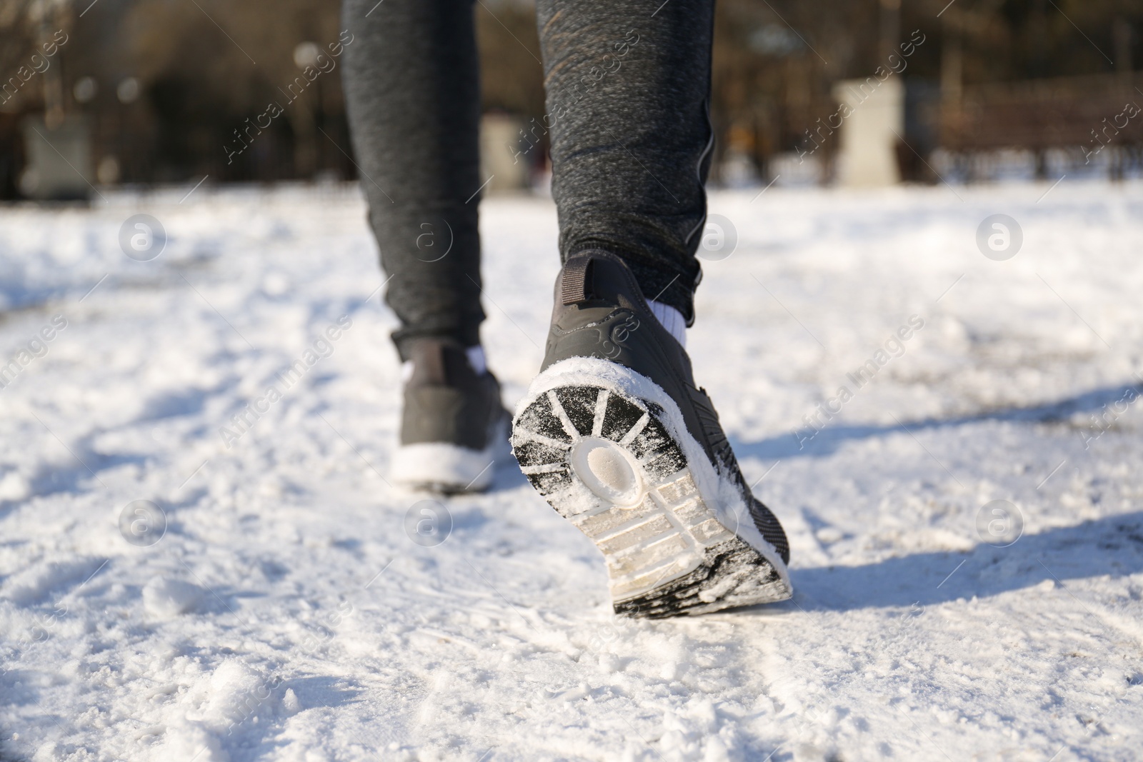 Photo of Woman running along park on winter day, closeup. Outdoors sports exercises