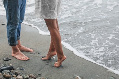 Photo of Young couple on beach near sea, closeup. Space for text