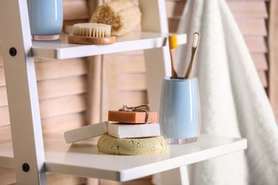 Photo of Soap and toiletries on wooden shelves in bathroom