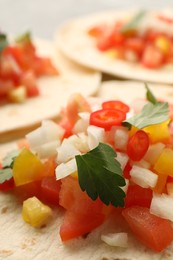 Photo of Delicious tacos with vegetables and parsley on table, closeup