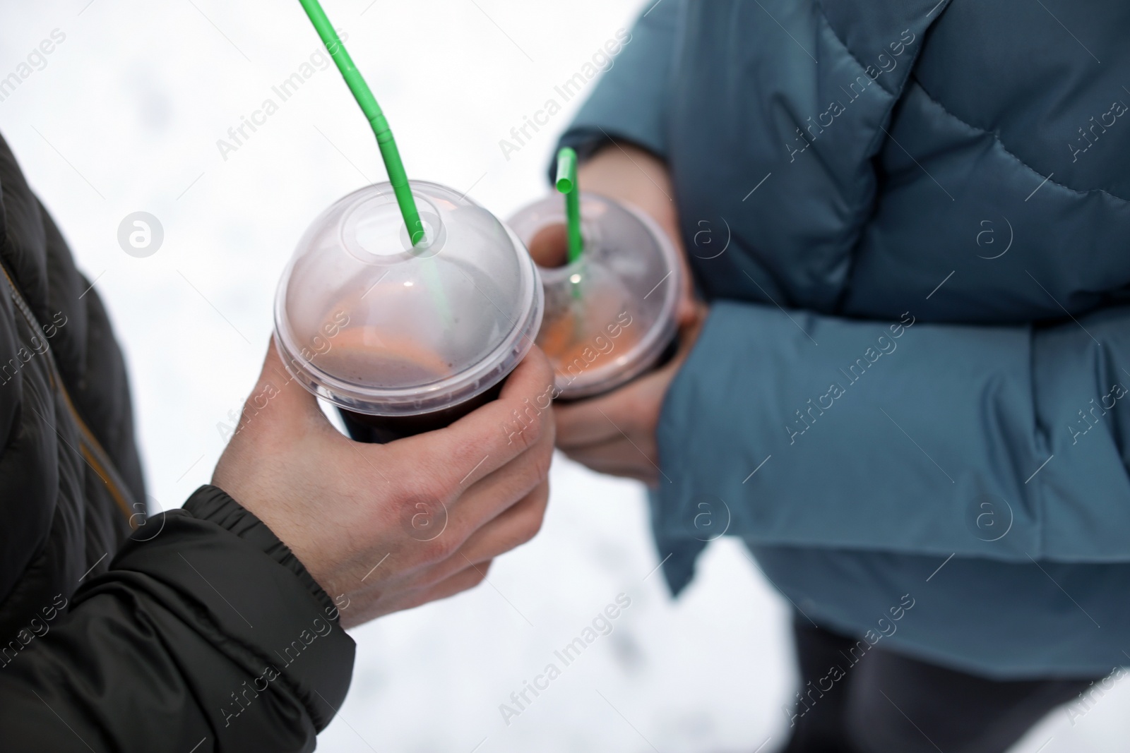 Photo of Young couple with cups of mulled wine outdoors, closeup