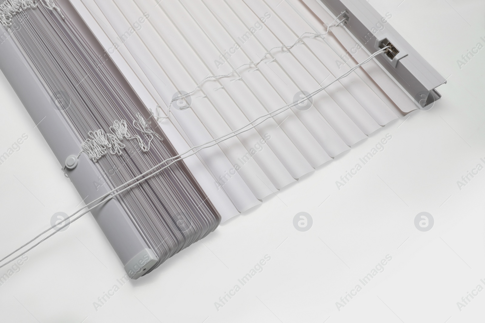 Photo of Stylish horizontal window blinds on white background, above view