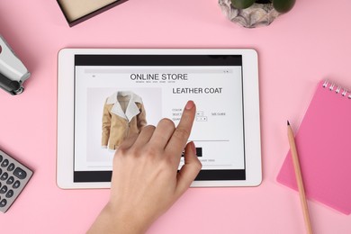 Photo of Woman with tablet shopping online on pink background, top view