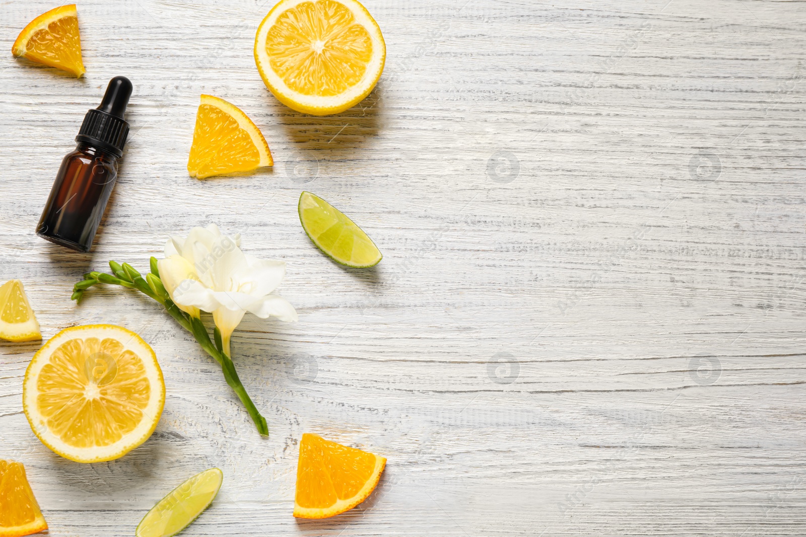 Photo of Flat lay composition with bottle of citrus essential oil on white wooden background. Space for text