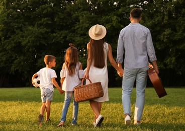 Photo of Happy family with picnic basket in park