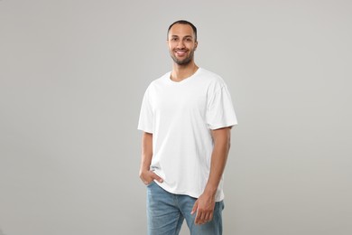 Man wearing white t-shirt on gray background