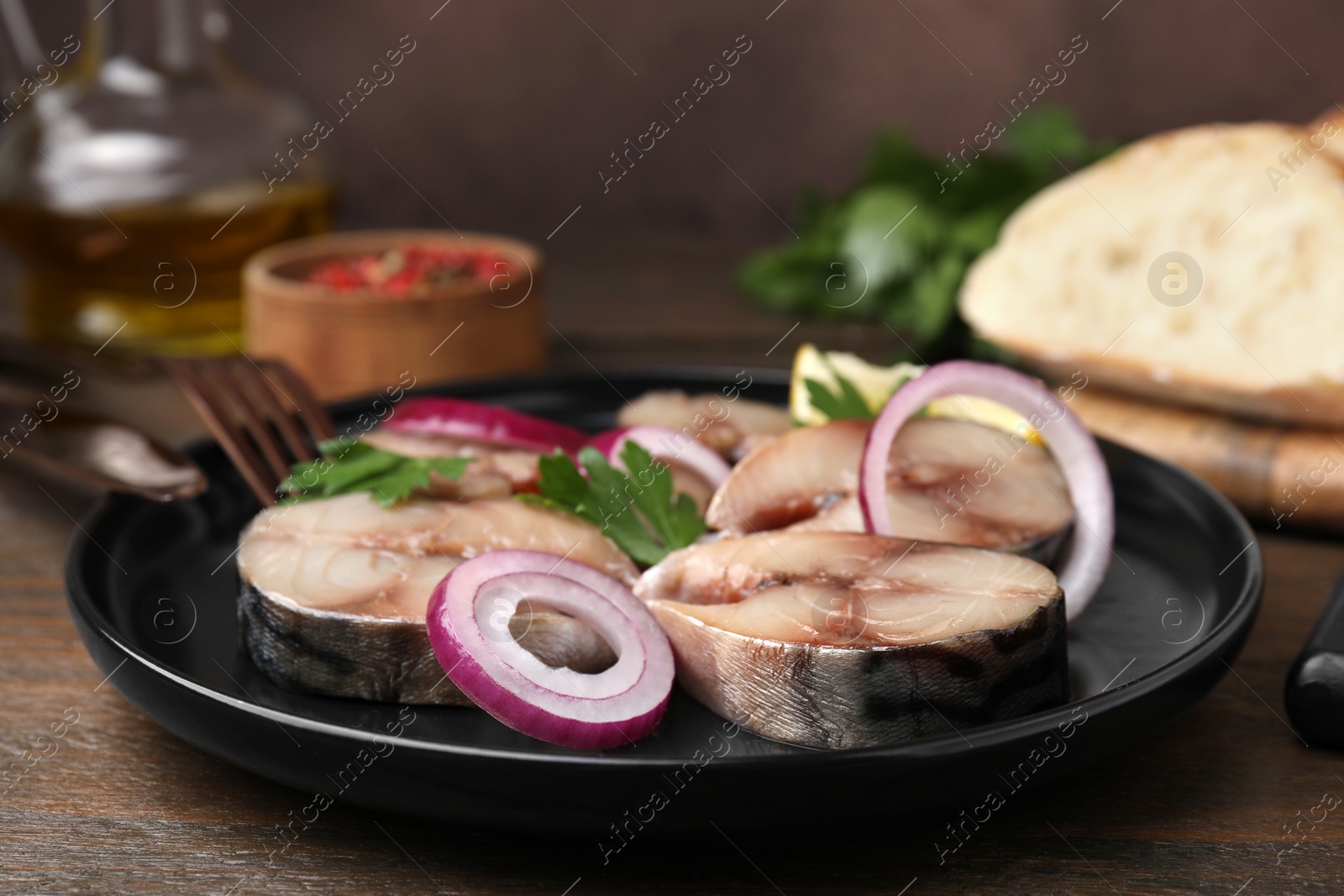 Photo of Slices of tasty salted mackerel and onion rings on table, closeup