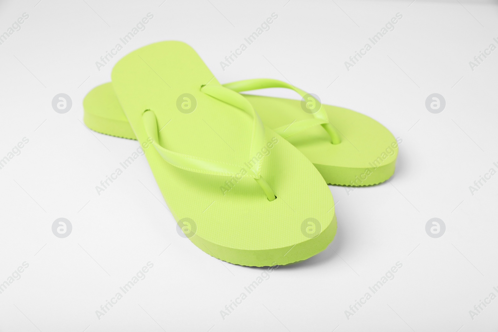 Photo of Stylish light green flip flops on white background