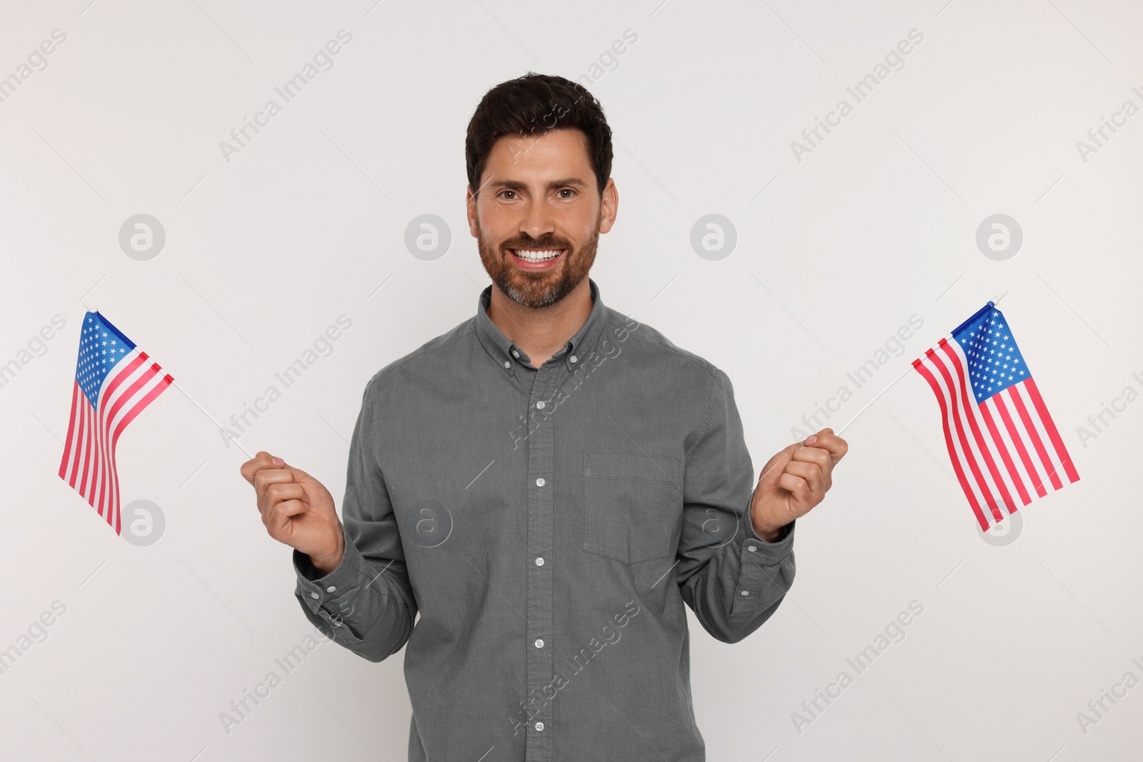 Photo of 4th of July - Independence Day of USA. Happy man with American flags on white background