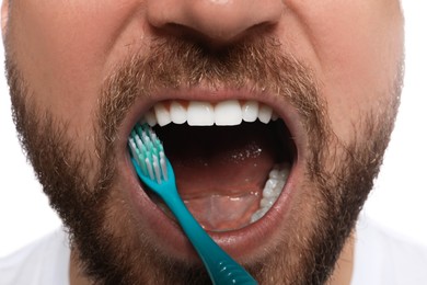 Photo of Man brushing teeth on white background, closeup. Dental care
