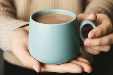 Photo of Woman holding cup of delicious hot cocoa, closeup