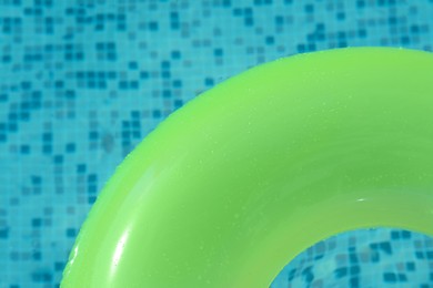Photo of Top view of light green inflatable ring floating in swimming pool, closeup