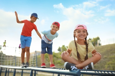 Photo of Cute children on playground climber outdoors. Summer camp