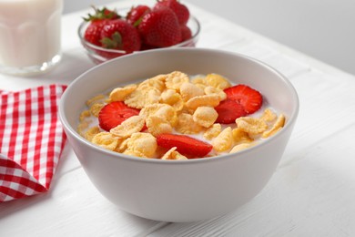 Photo of Corn flakes with strawberries in bowl served on white wooden table, closeup