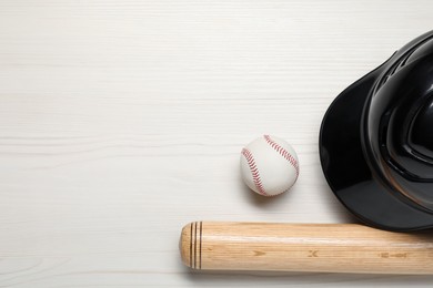 Sports equipment. Helmet, ball and baseball bat on white wooden table, flat lay. Space for text