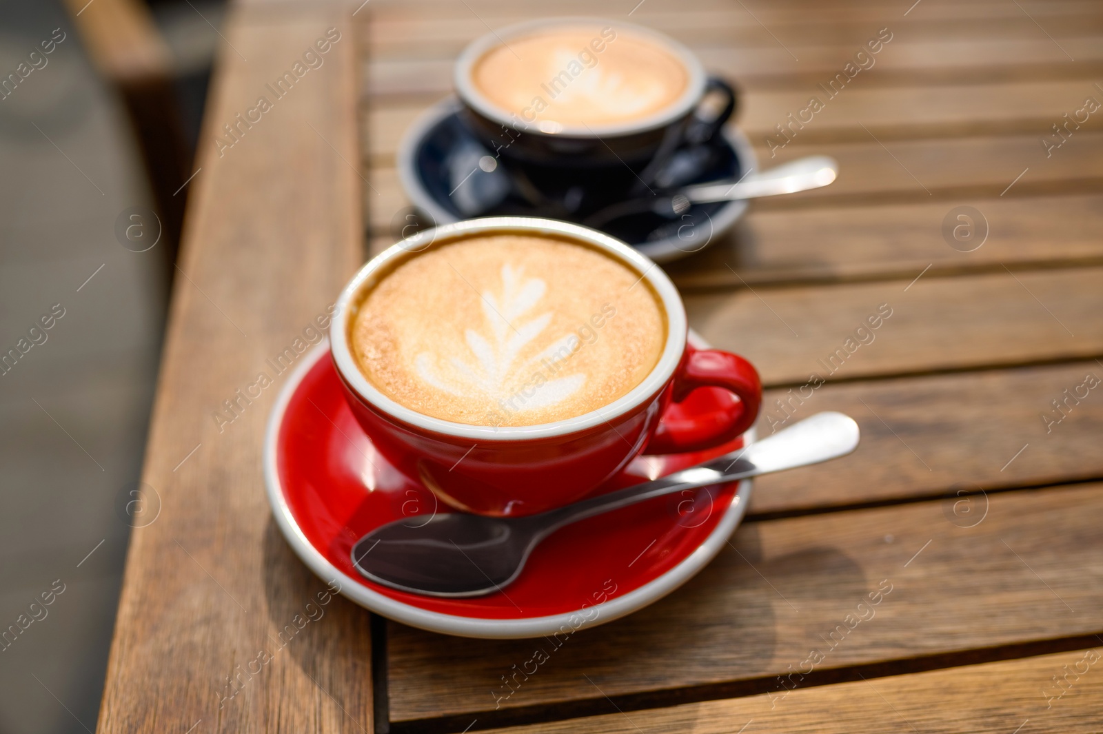 Photo of Cups of aromatic coffee on wooden table