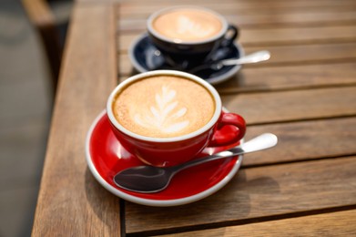 Cups of aromatic coffee on wooden table