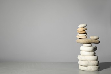 Photo of Stack of stones on grey background, space for text. Harmony and balance concept