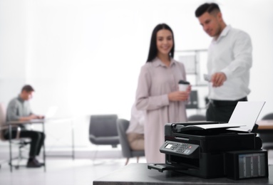 Photo of New modern printer on table in office. Space for text