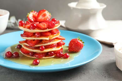 Photo of Tasty pancakes with berries and honey on plate