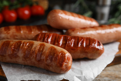 Delicious grilled sausages on wooden table, closeup