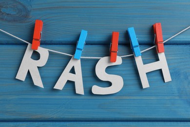 Photo of Word Rash hanging on turquoise wooden background
