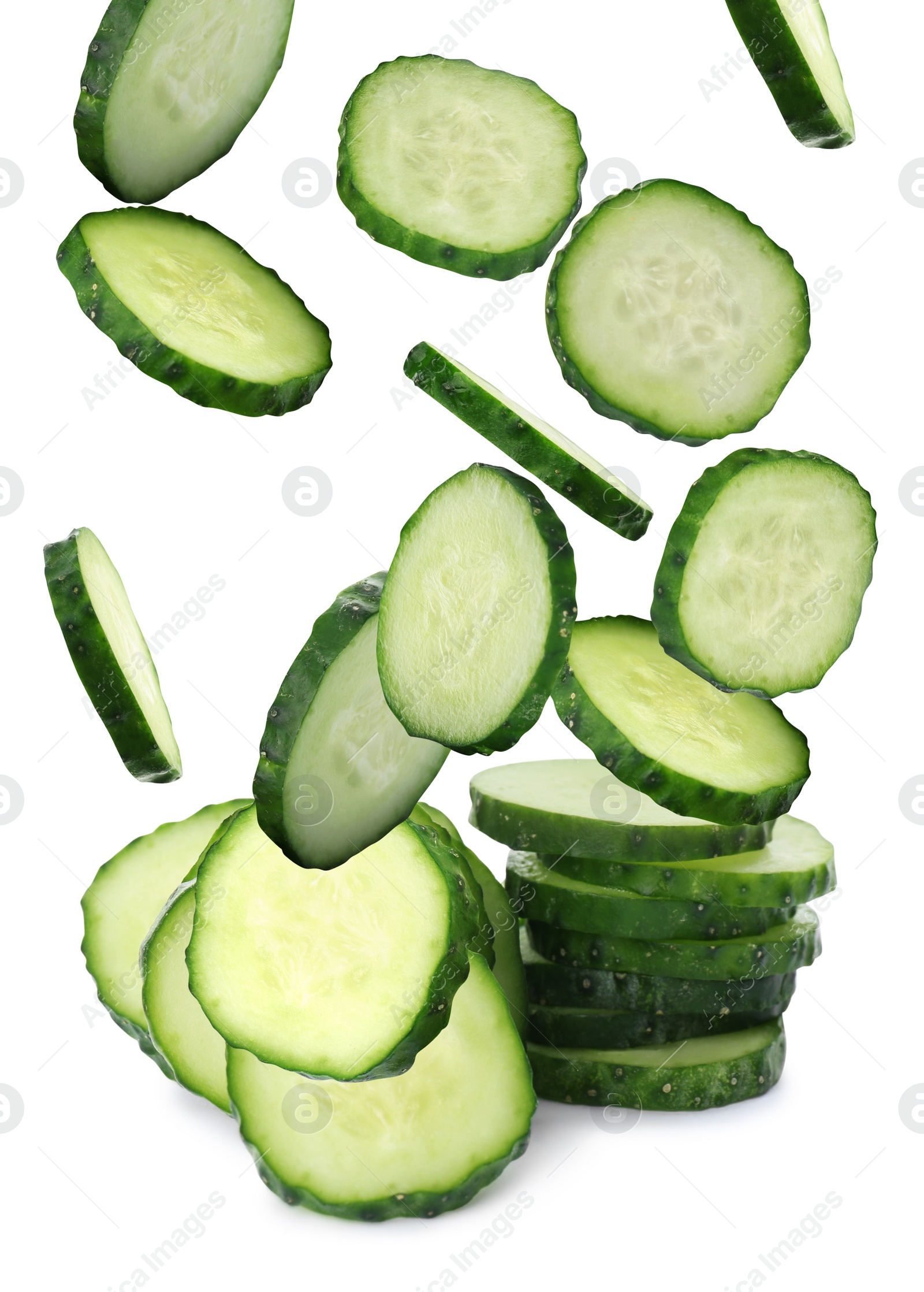 Image of Slices of fresh green cucumbers falling on white background