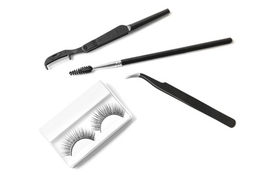 Composition with false eyelashes and tweezers on white background