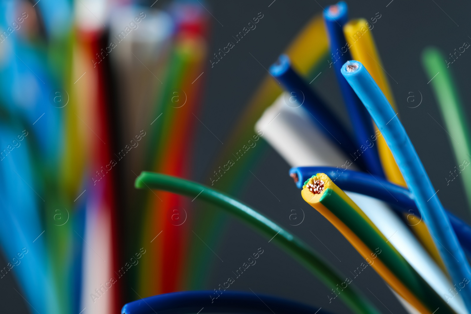 Photo of Colorful cables on blurred background, closeup with space for text. Electrician's supply