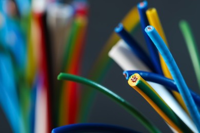 Colorful cables on blurred background, closeup with space for text. Electrician's supply