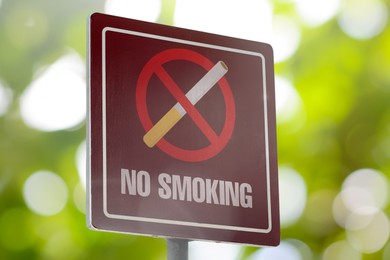 Image of Sign No Smoking outdoors on sunny day. Bokeh effect