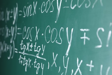 Many different math formulas written on chalkboard, closeup