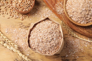 Wheat bran on wooden table, flat lay