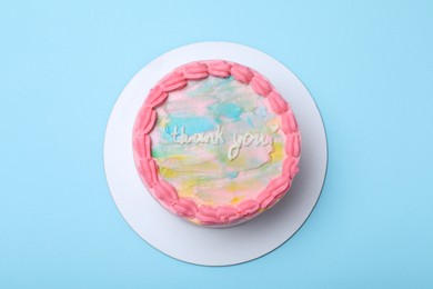 Photo of Cute bento cake with tasty cream on light blue background, top view