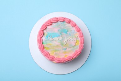 Cute bento cake with tasty cream on light blue background, top view