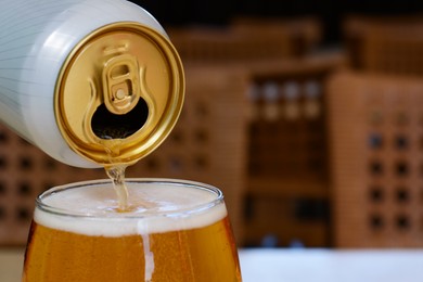 Photo of Pouring beer from can into glass on table indoors, closeup. Space for text