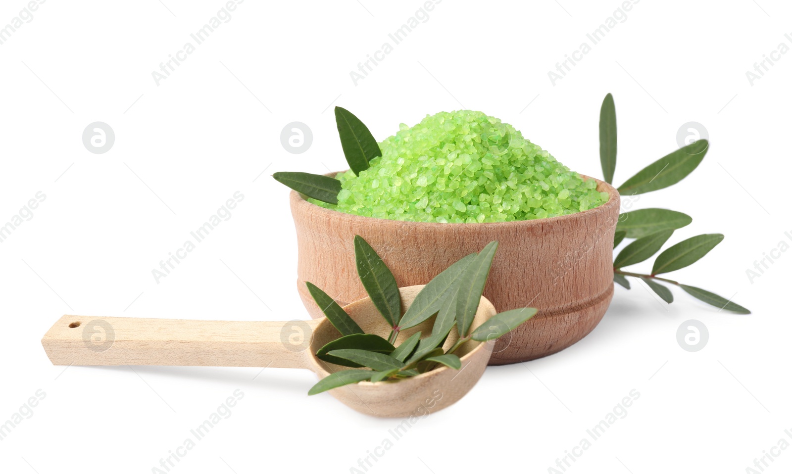 Photo of Wooden bowl with green sea salt, spoon and leaves on white background